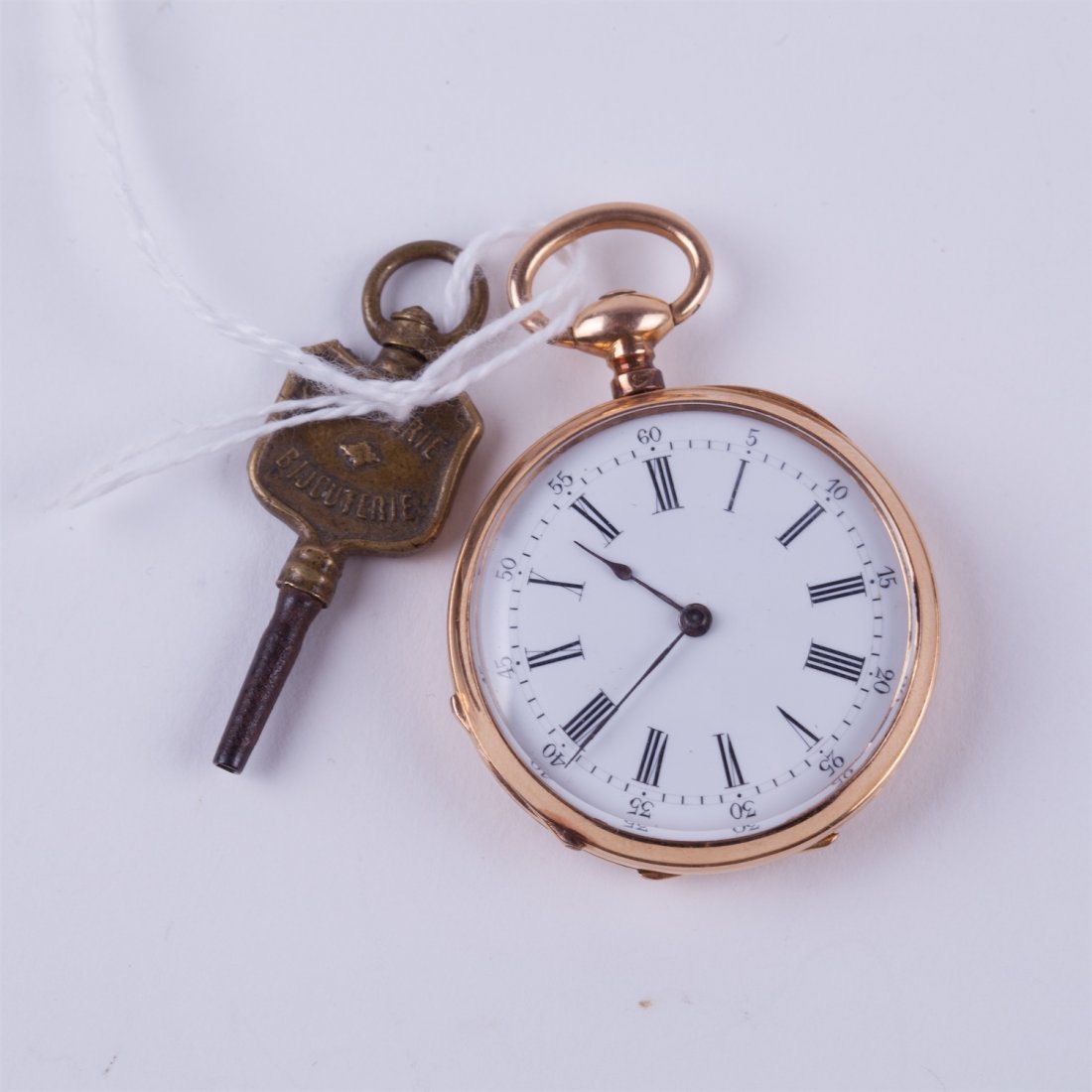Open face gold pocket watch with key. — image 1